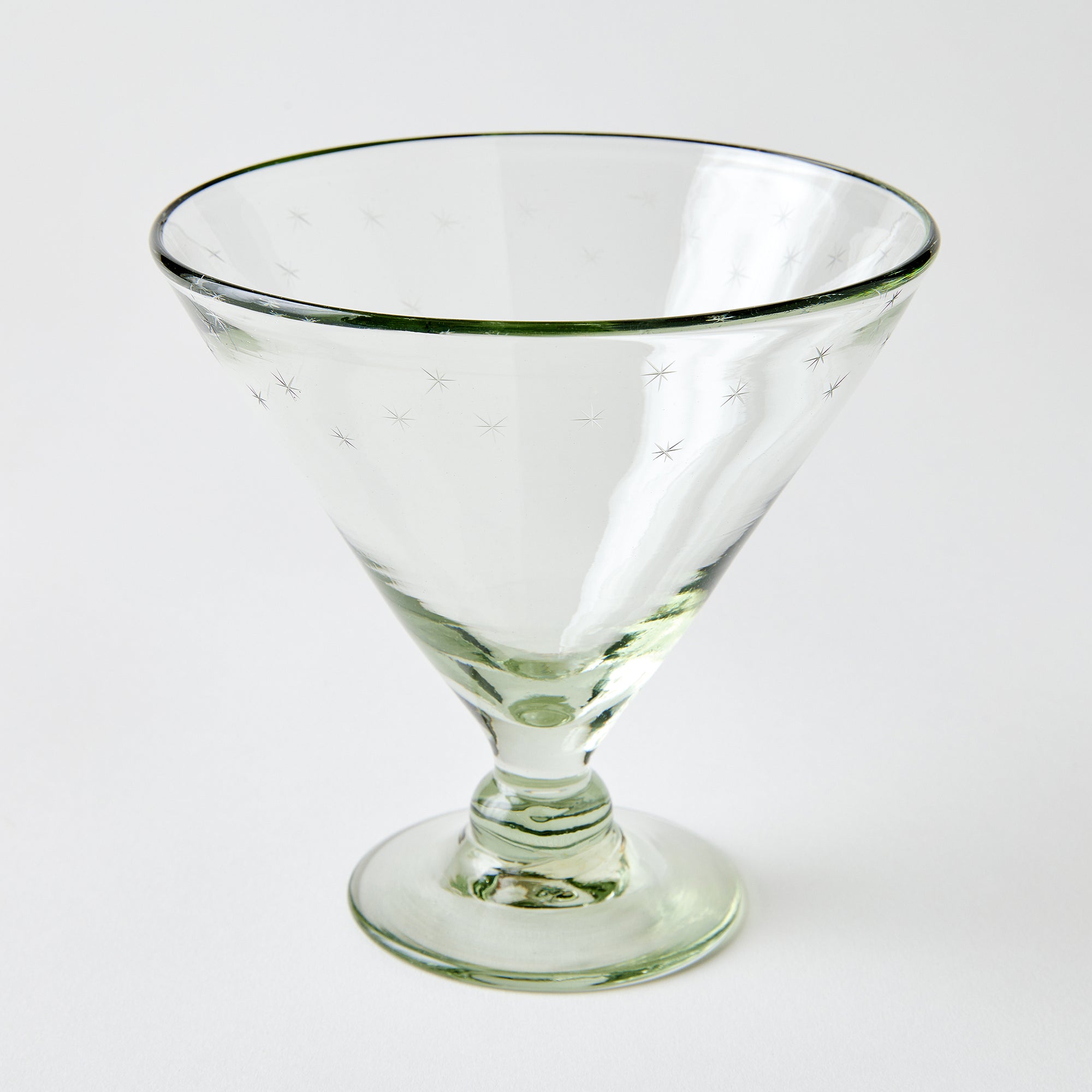 Clear footed dish glass etched with stars on a white background