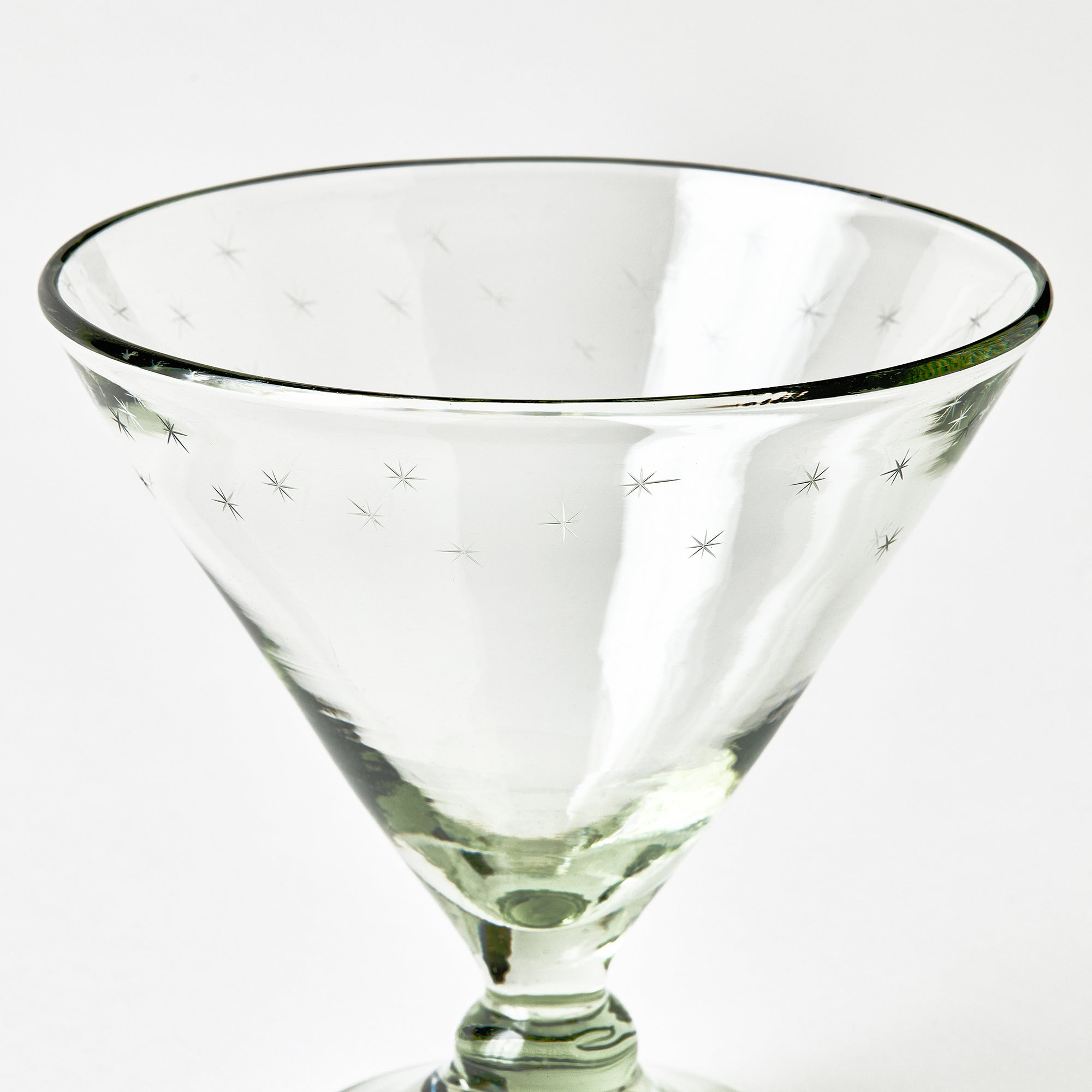 Clear footed dish glass with star patterns on a white background