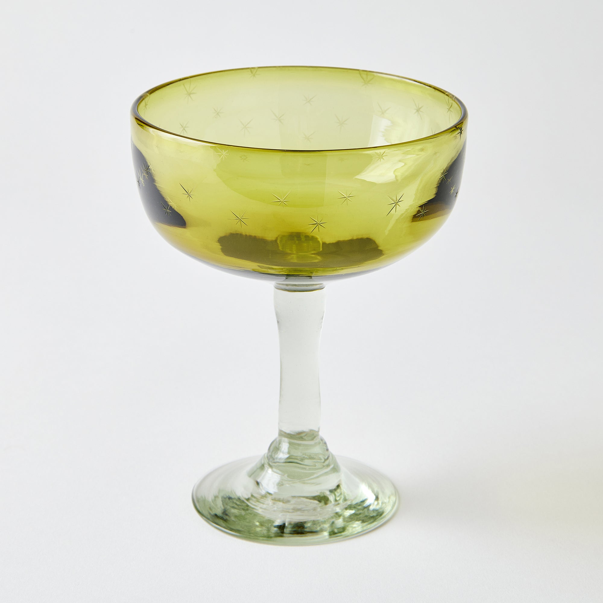 Yellow margarita glass with clear stem, etched with stars, on a white background