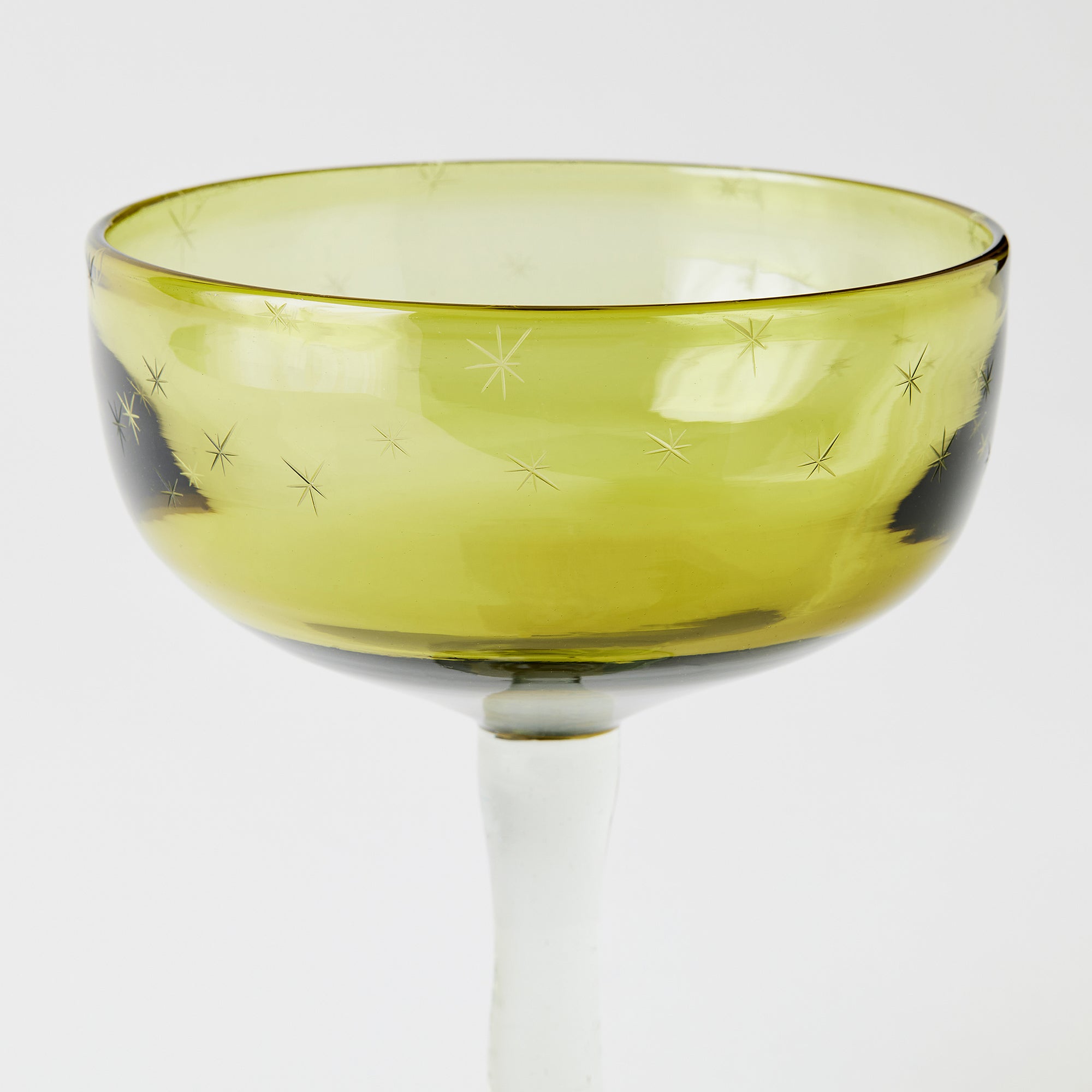 Yellow margarita glass with star patterns on a white background