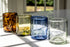 Four glass tumblers on a windowsill with a blurred outdoor background